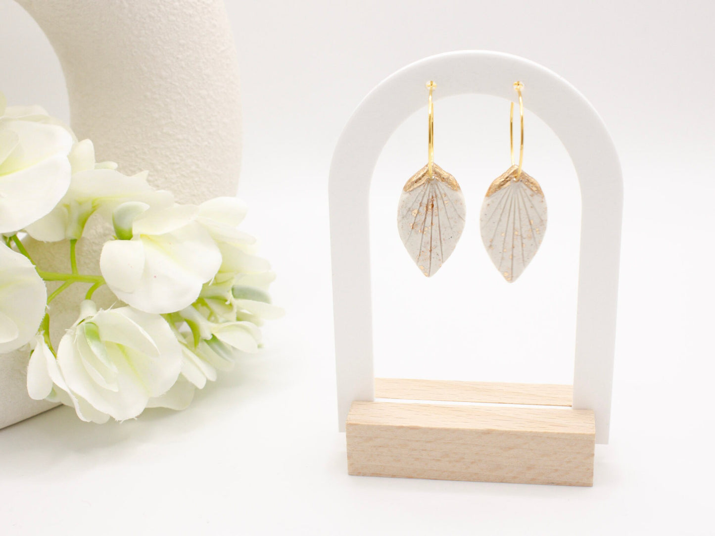 Handmade white and gold tropical leaf clay hoop earrings by Cove Clay Designs
