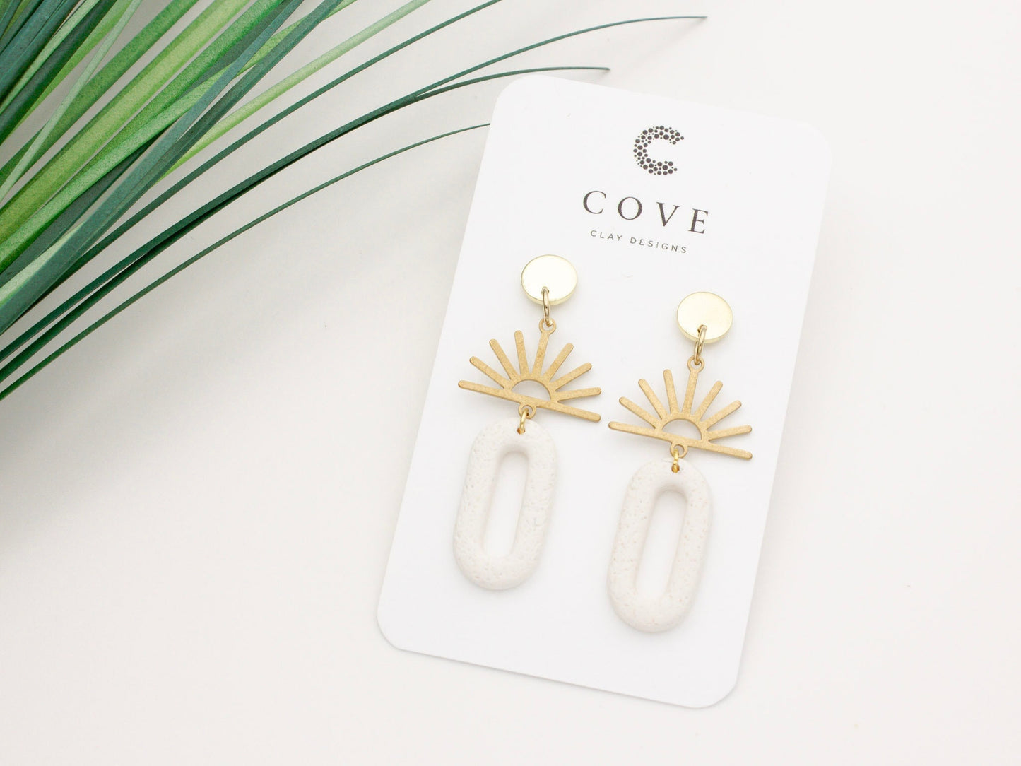 Handmade gold sun and white dangle polymer clay earrings by Cove Clay Designs