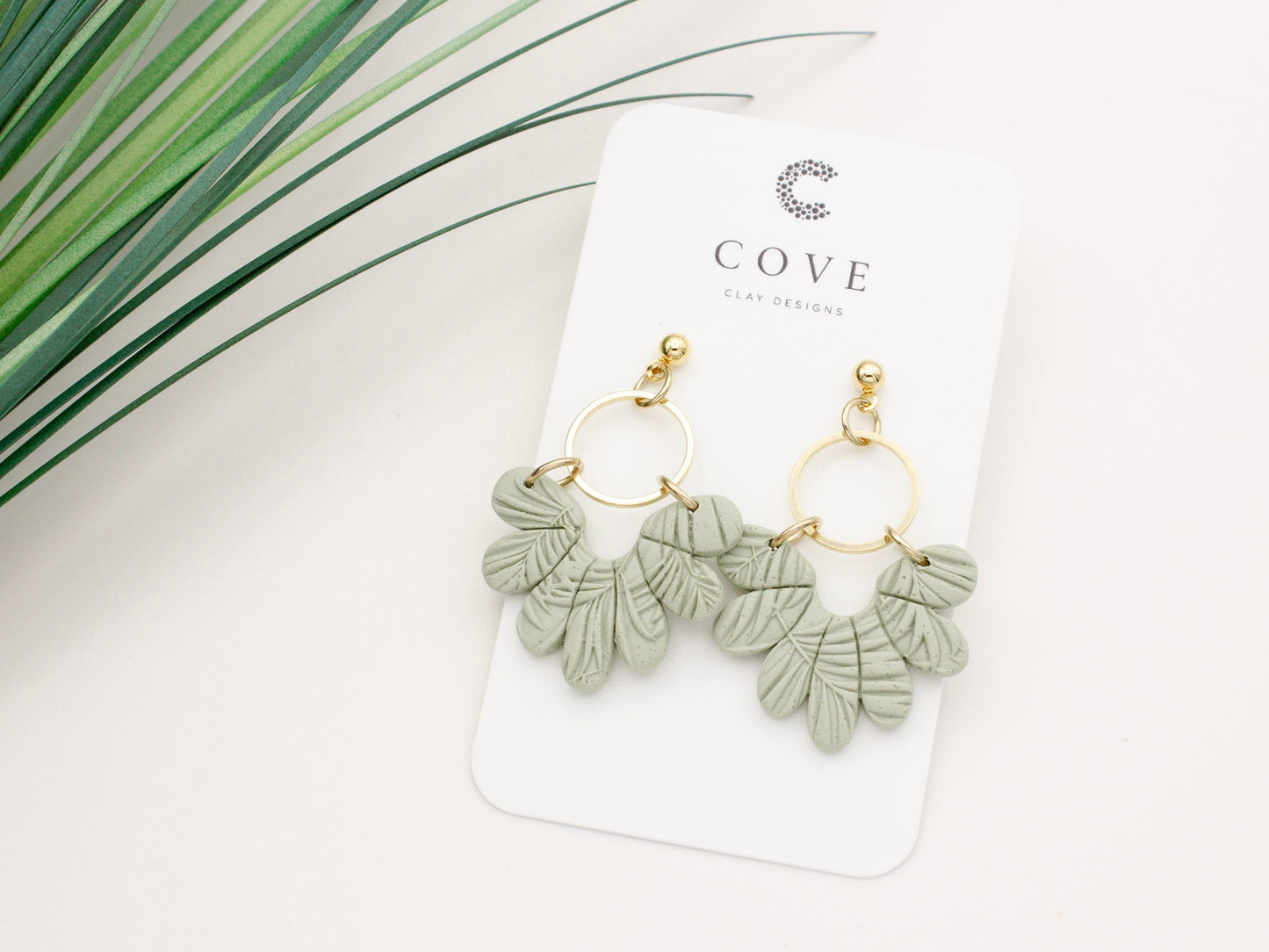 Handmade tropical green leaf polymer clay dangle earrings with gold hoop connectors by Cove Clay Designs