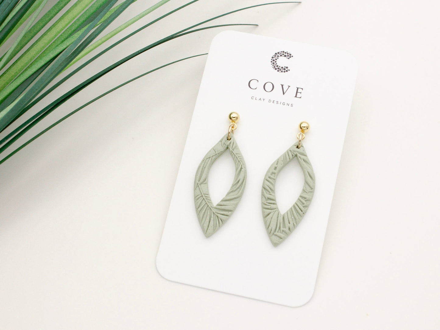 Handmade green tropical leaf print clay dangle earrings by Cove Clay Designs
