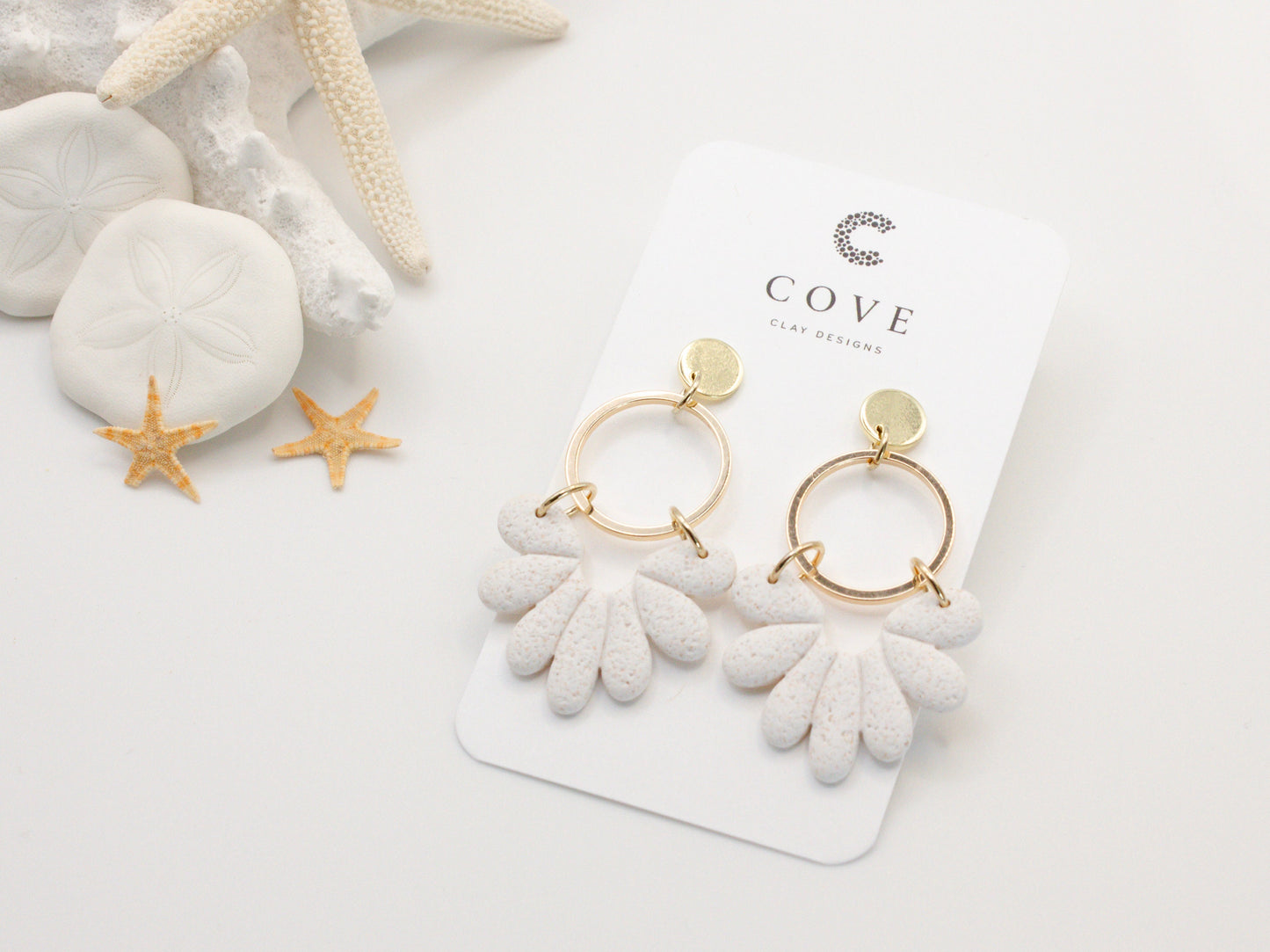 Handmade white sand effect scallop shell hoop dangle clay earrings with gold posts and round connectors by Cove Clay Designs