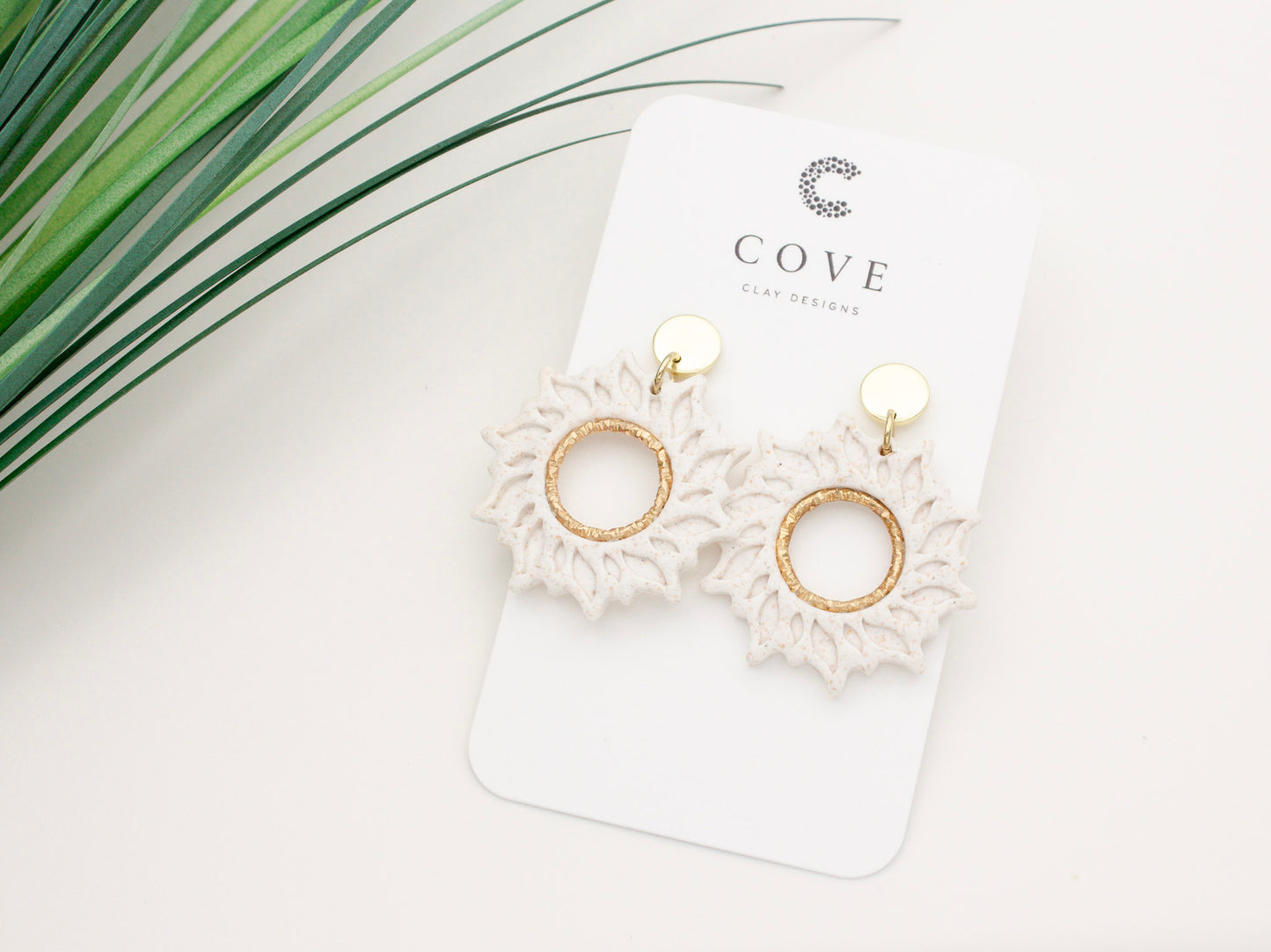 Handmade white sun dangle clay earrings with gold posts by Cove Clay Designs