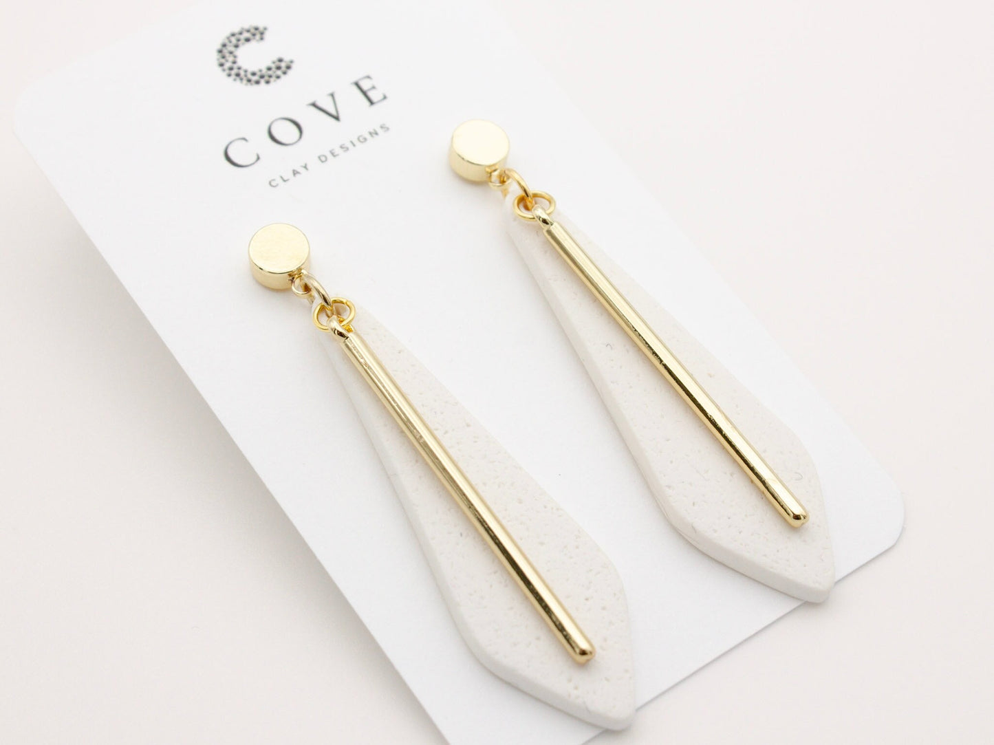 Handmade long white clay dangle earrings with gold posts by Cove Clay Designs