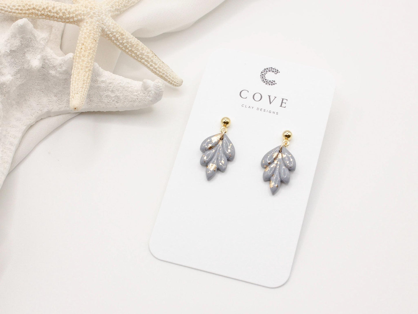 Handmade mini dusty blue and speckled gold leaf polymer clay earrings by Cove Clay Designs