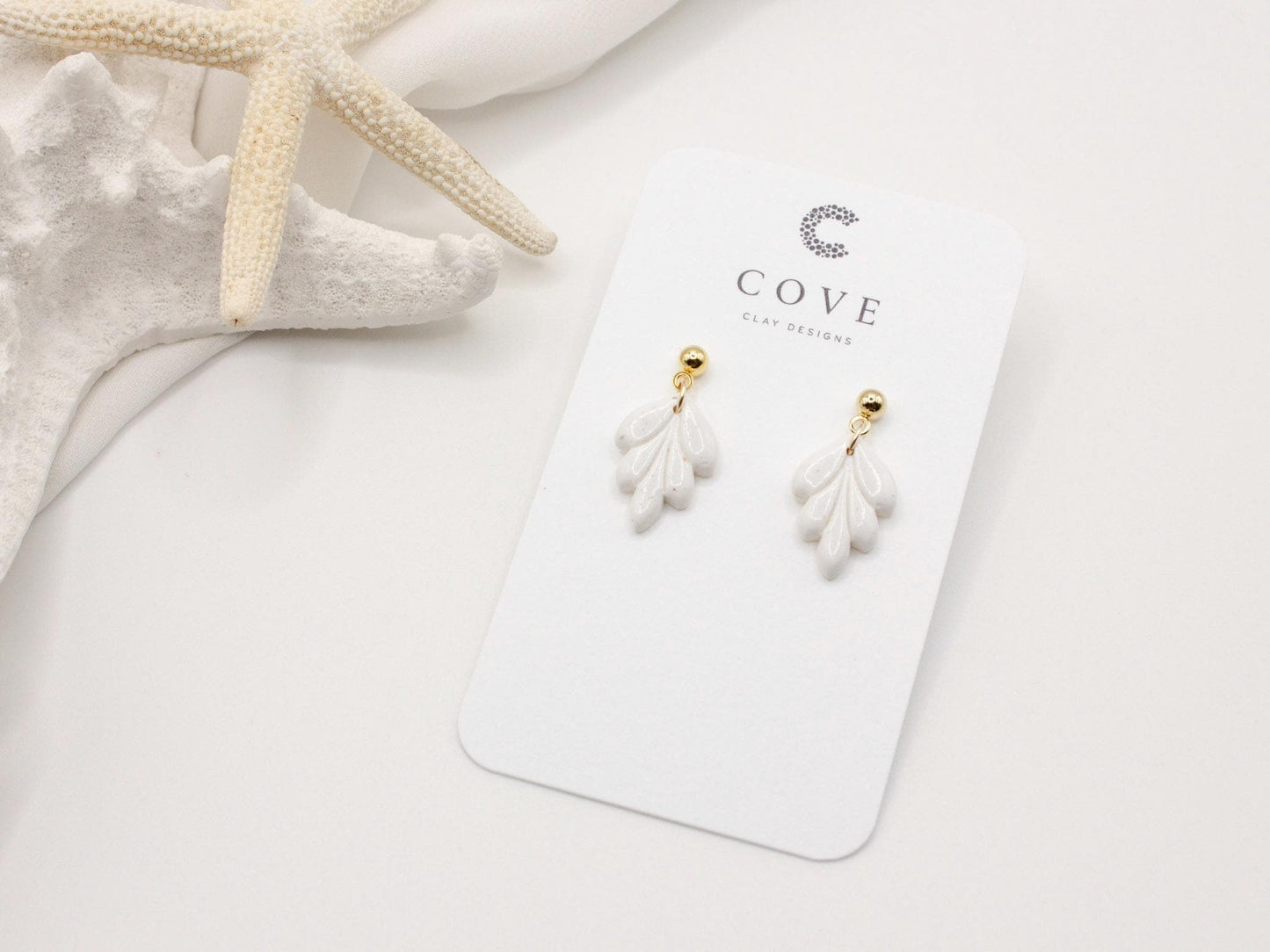 Handmade mini white leaf polymer clay earrings by Cove Clay Designs