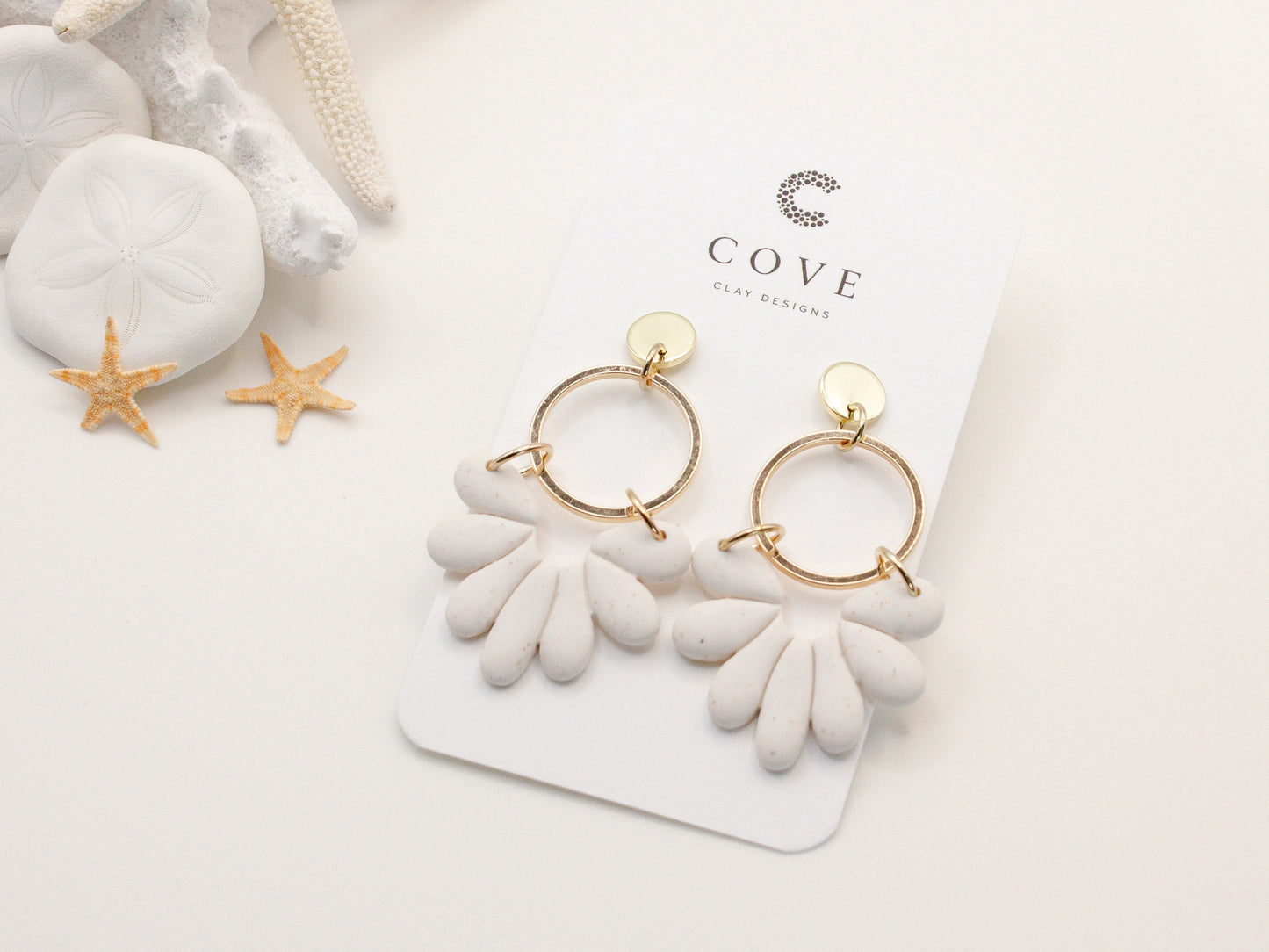 Handmade white sand effect scallop shell hoop dangle clay earrings with gold posts and round connectors by Cove Clay Designs