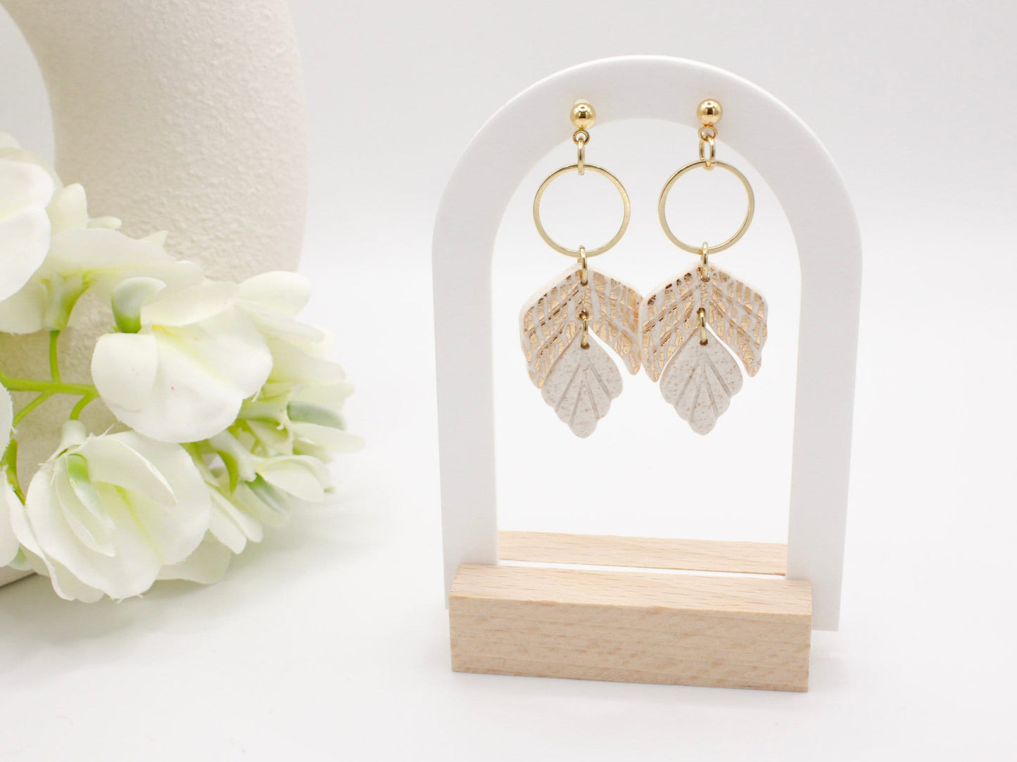 Handmade white and gold leaf clay earrings with gold hoop connectors.