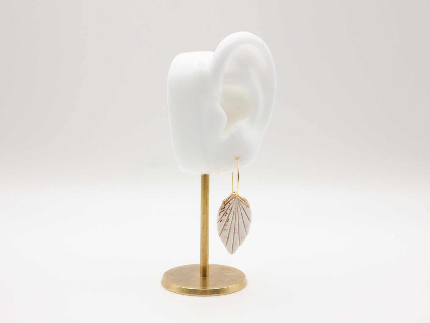 Handmade white and gold tropical leaf clay hoop earrings by Cove Clay Designs