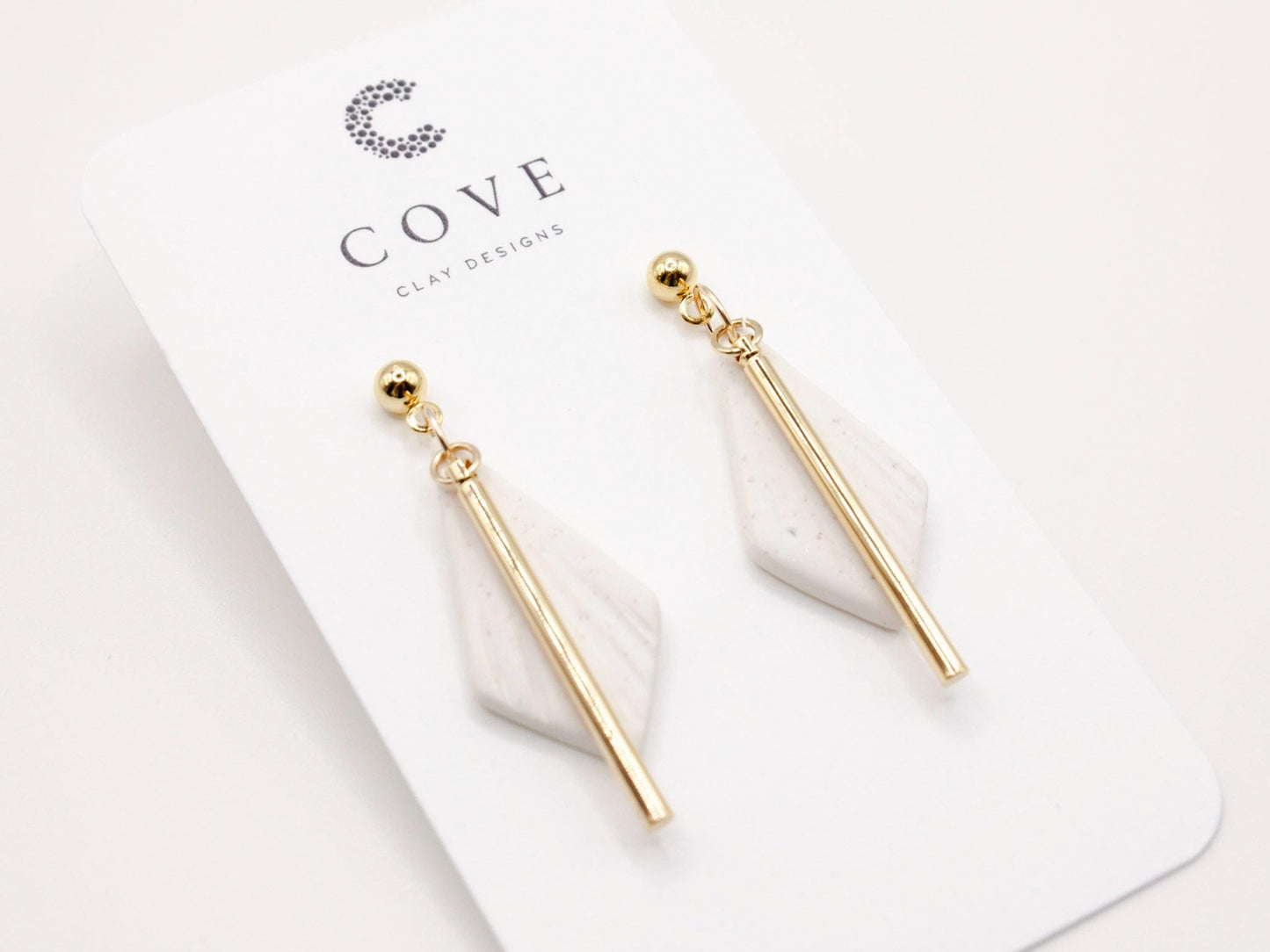 Handmade white diamond shaped polymer clay earrings with gold bar by Cove Clay Designs