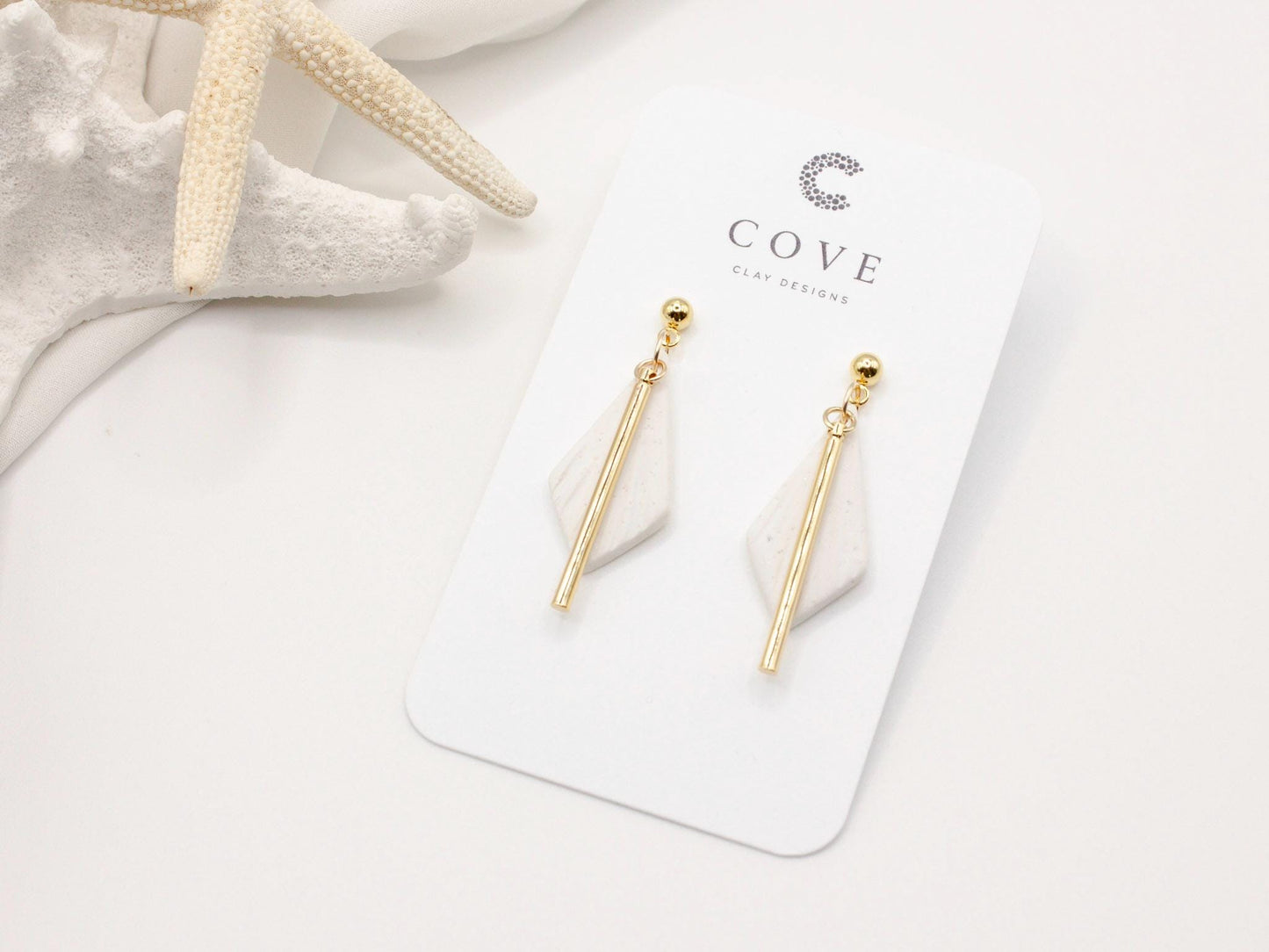 Handmade white diamond shaped polymer clay earrings with gold bar by Cove Clay Designs