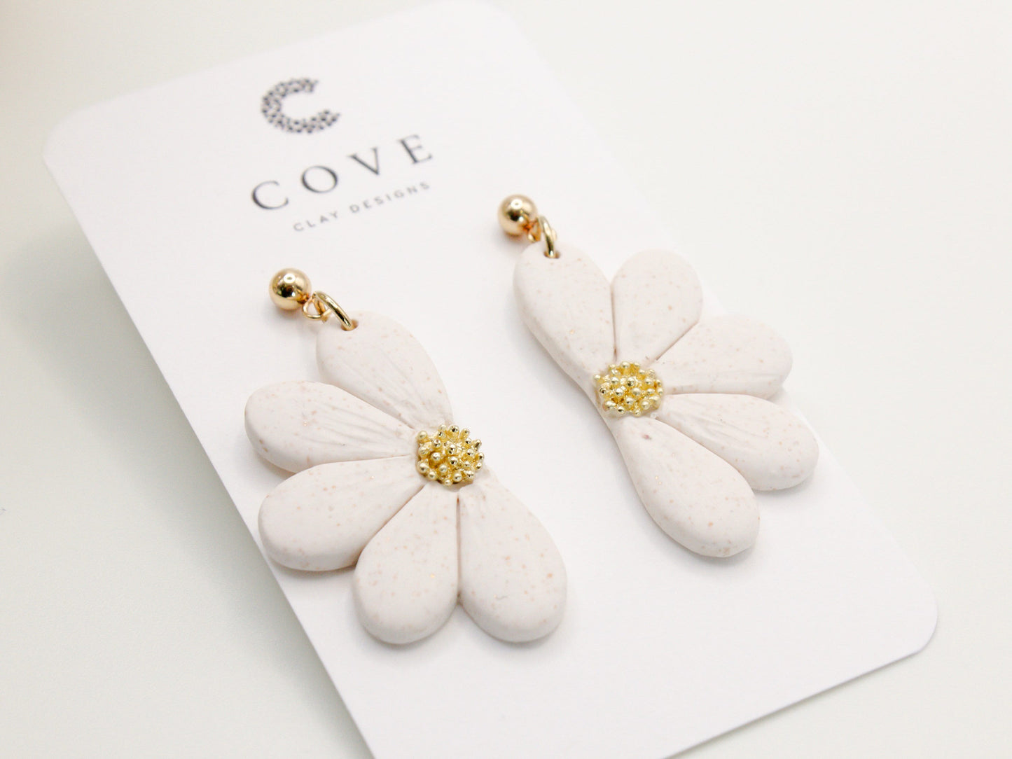 Handmade white flower polymer clay earrings with gold stud posts by Cove Clay Designs