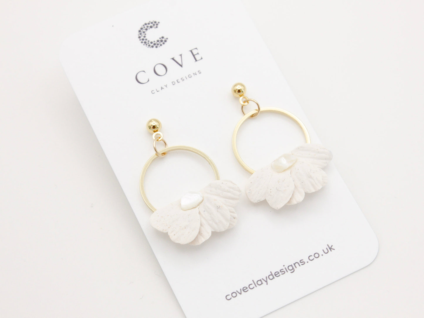 Handmade white petal hoop polymer clay earrings with gold stud posts.