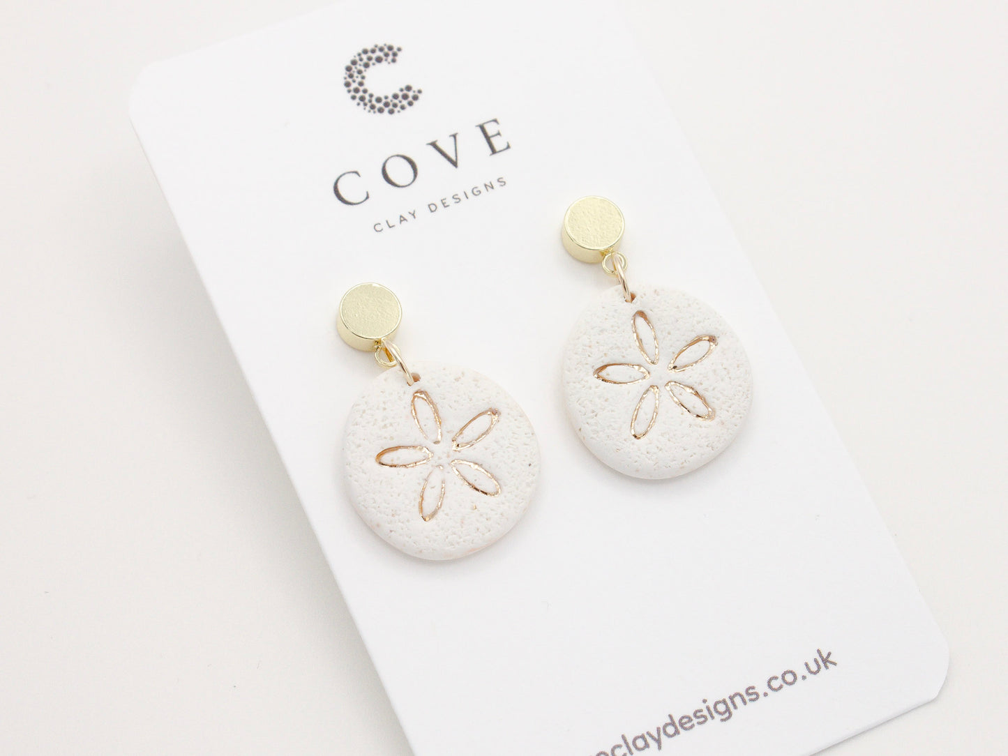 Handmade sand dollar polymer clay earrings with a delicate sand effect finish
