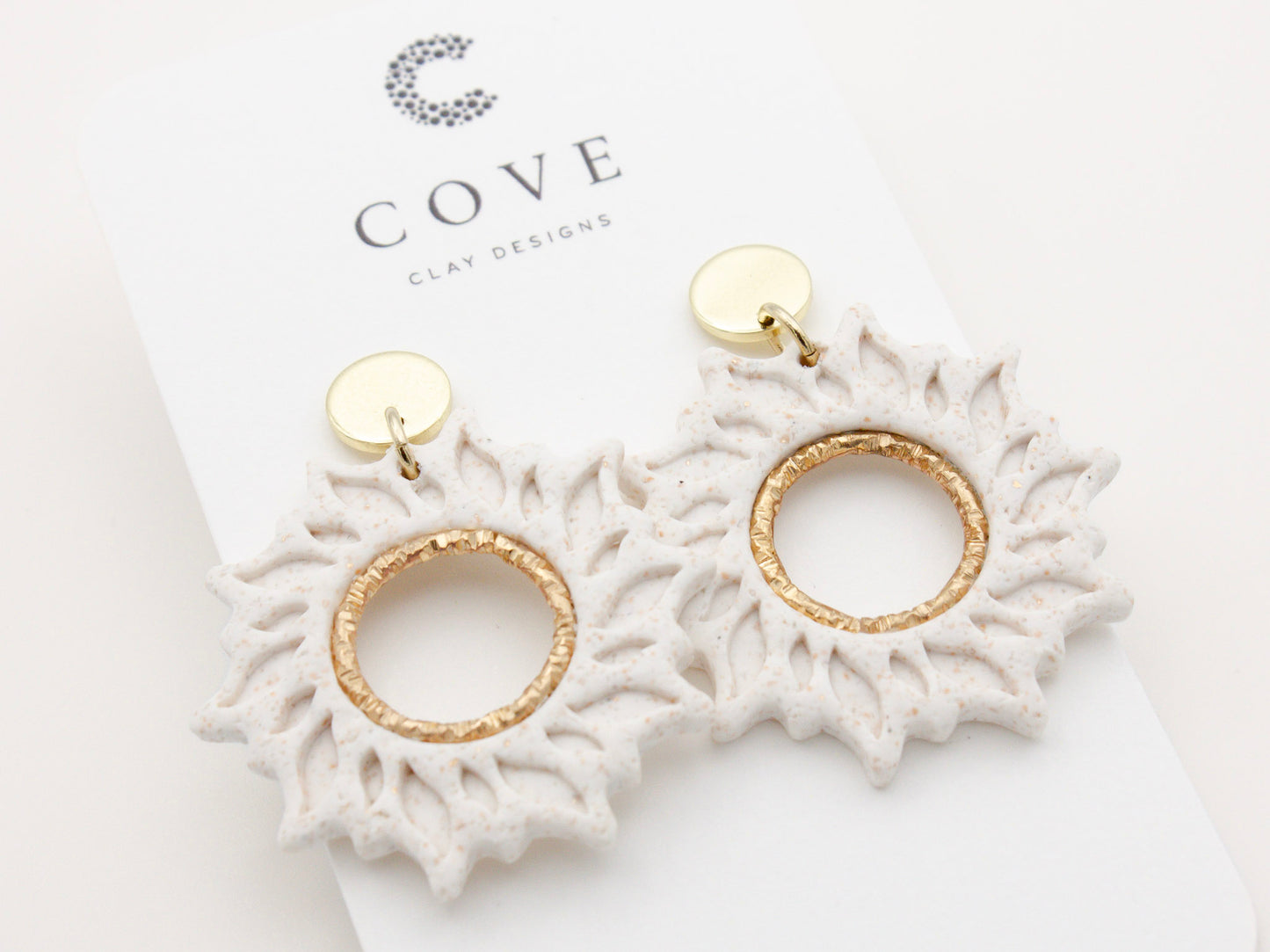 Handmade white sun dangle clay earrings with gold posts by Cove Clay Designs