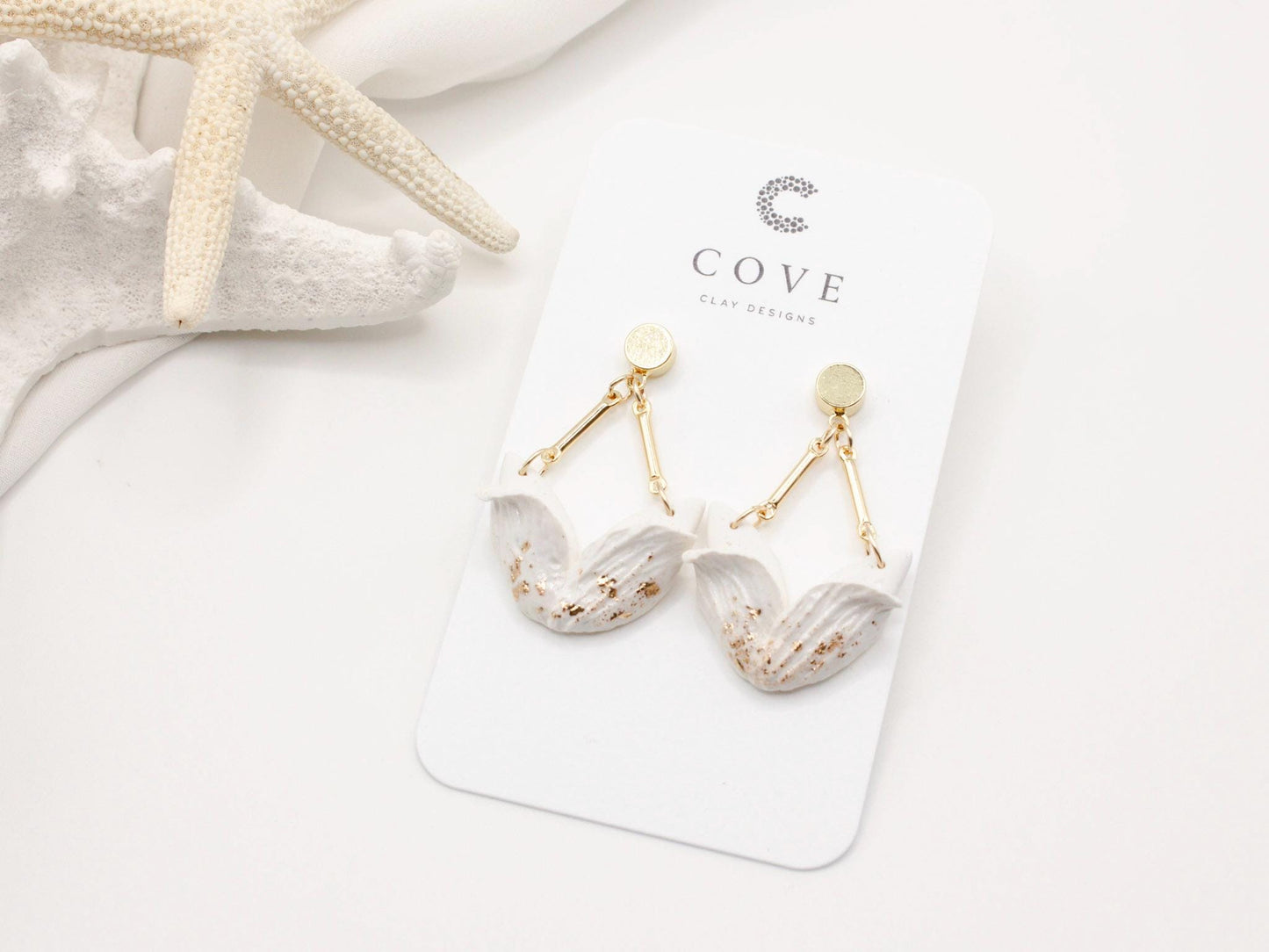 Handmade white tulip inspired clay dangle earrings with gold stud posts by Cove Clay Designs