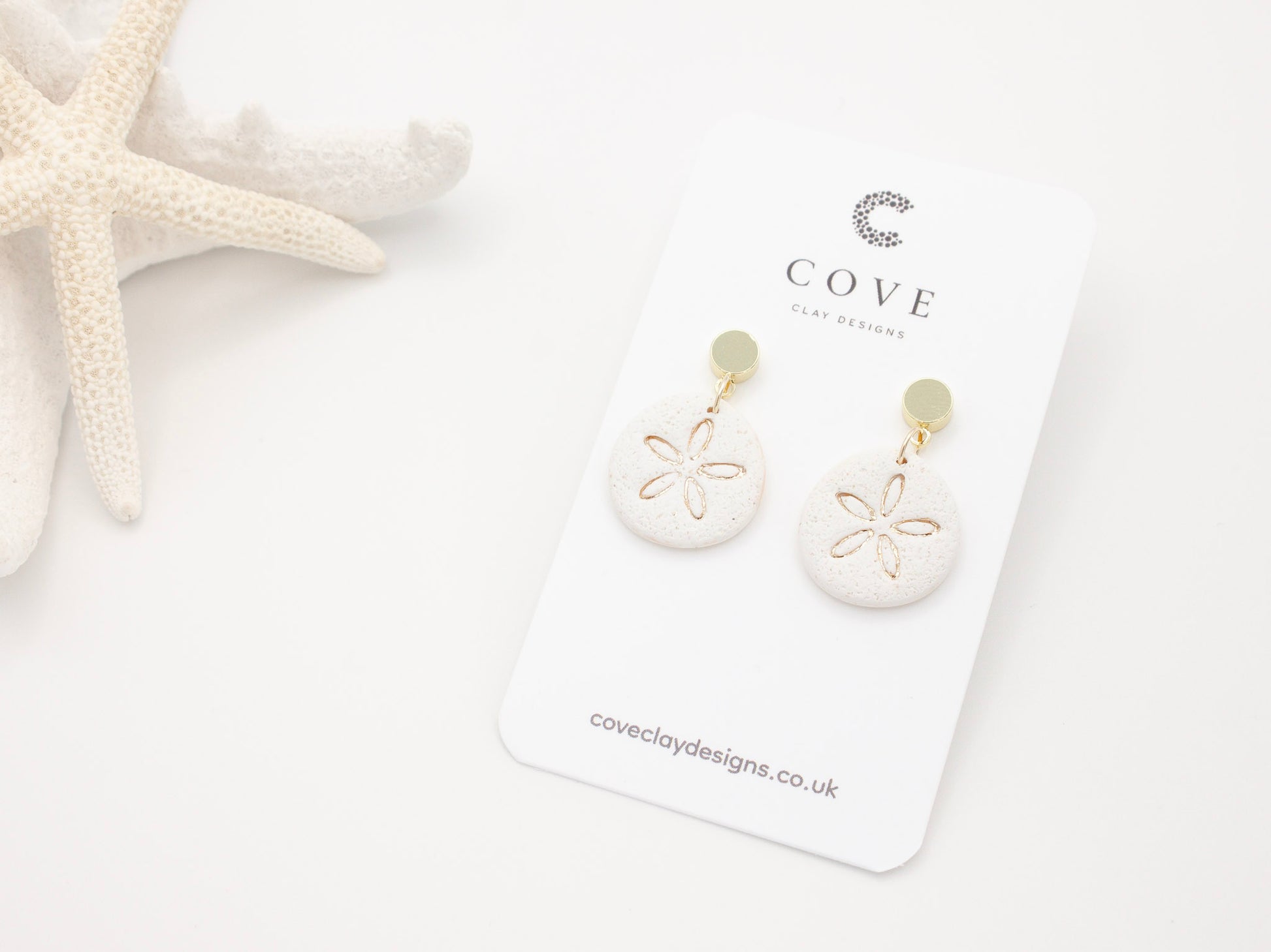 Handmade sand dollar polymer clay earrings with a delicate sand effect finish 