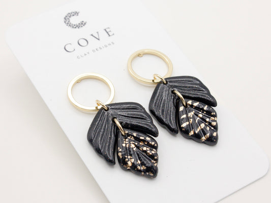 Handmade black and gold fleck double leaf polymer clay earrings.