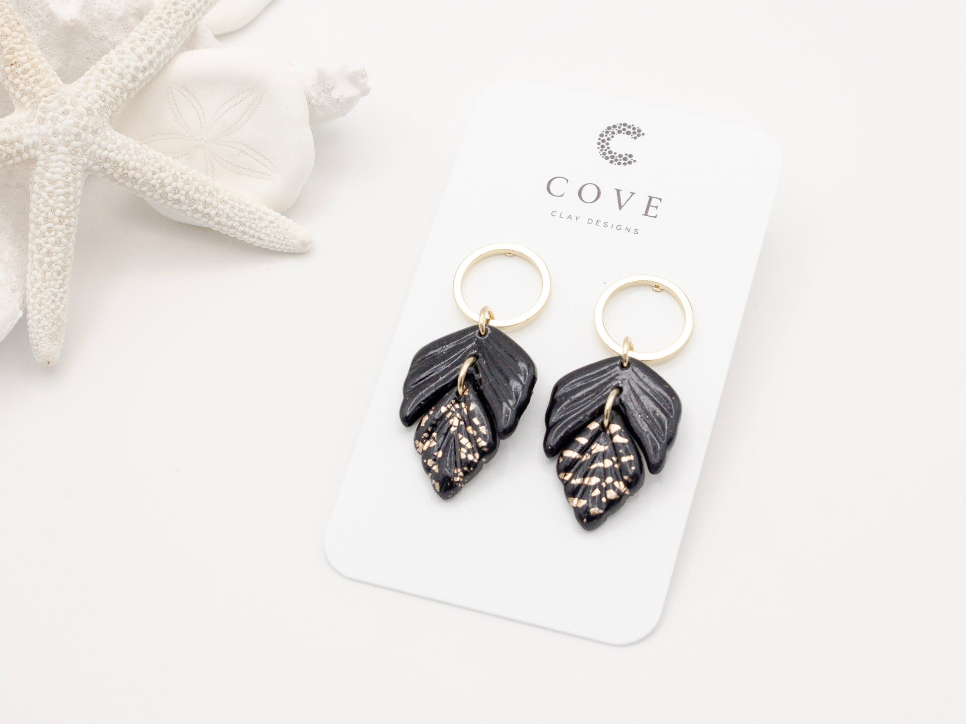 Handmade black and gold fleck double leaf polymer clay earrings.