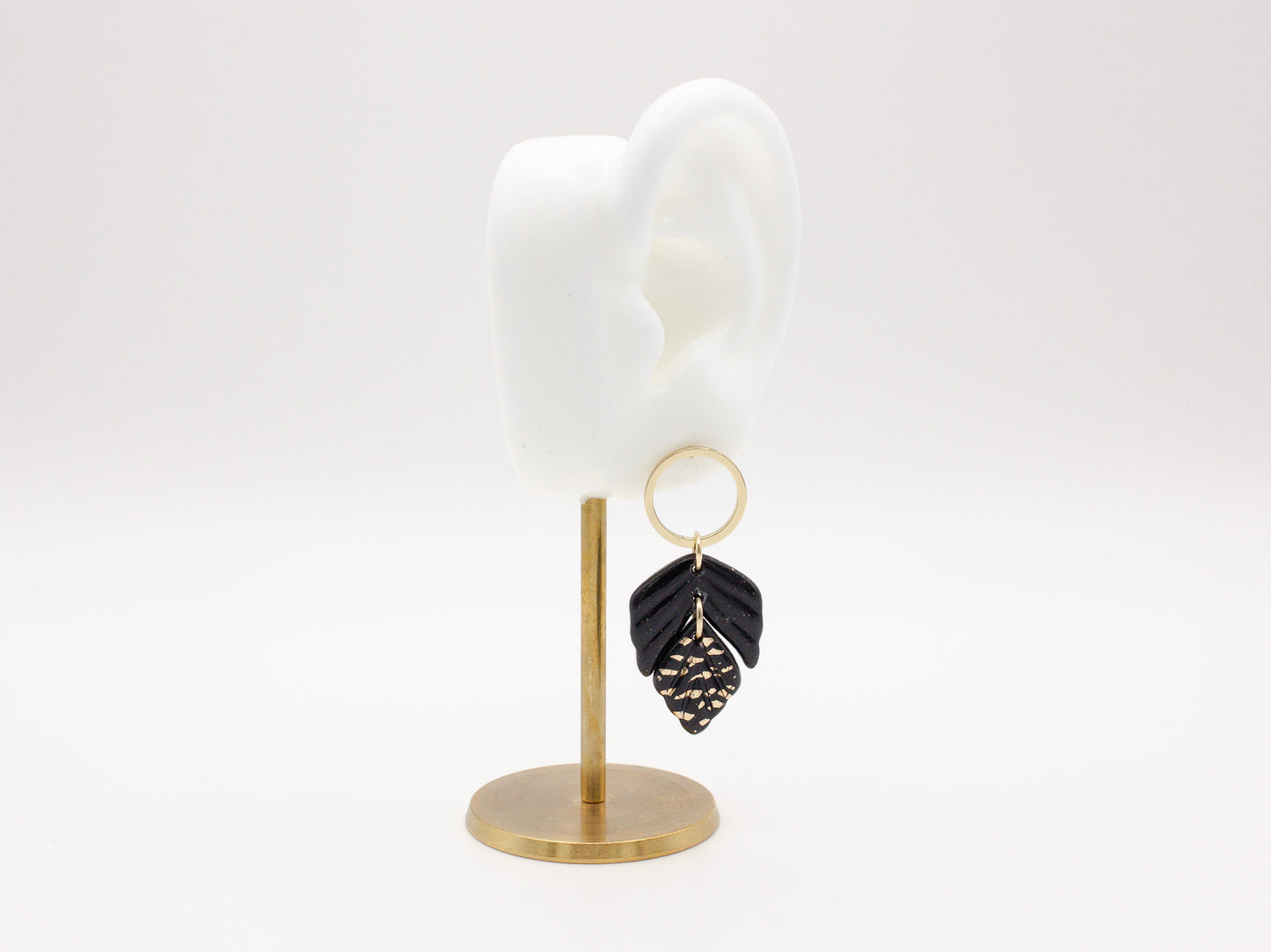 Handmade black and gold fleck double leaf polymer clay earrings.