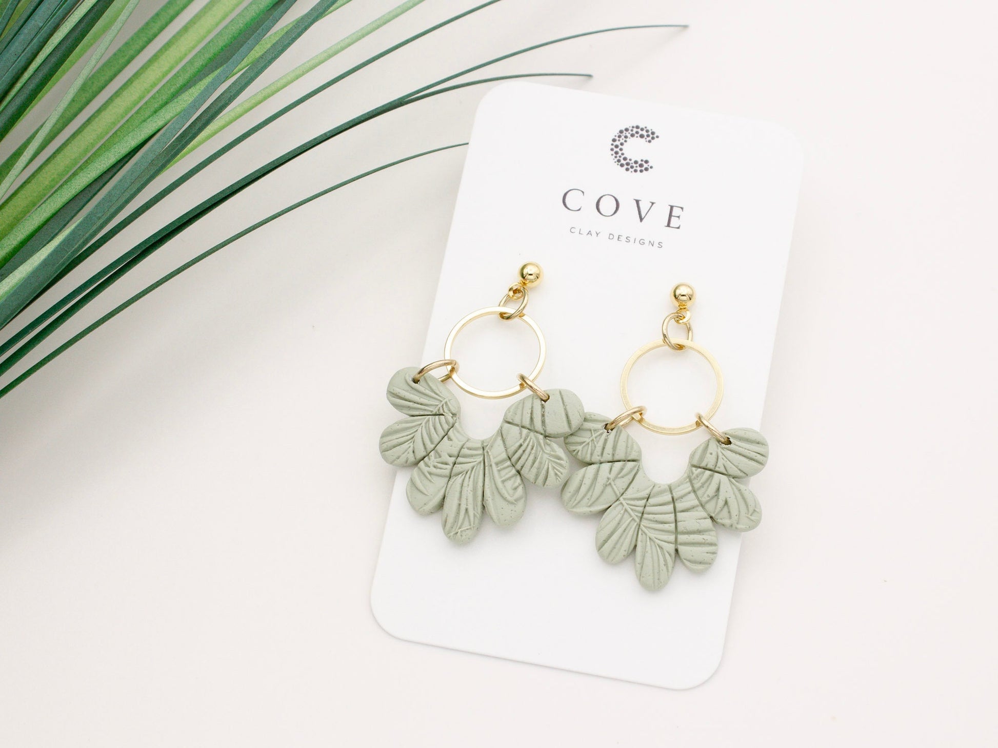 Handmade tropical green leaf polymer clay dangle earrings with gold hoop connectors by Cove Clay Designs