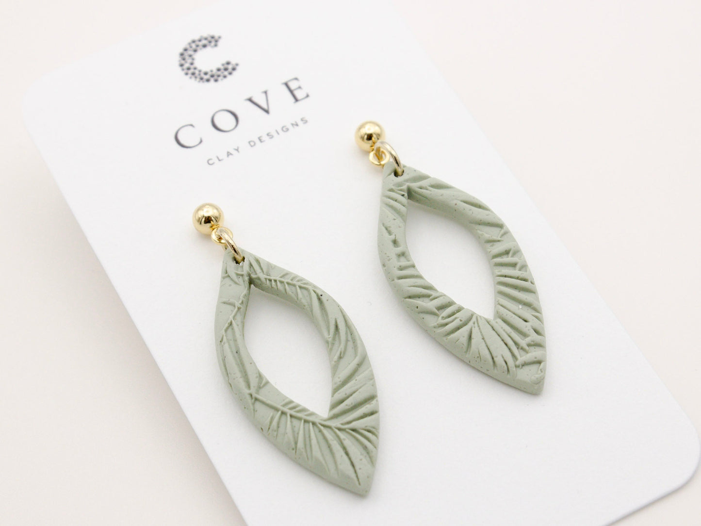 Handmade green tropical leaf print clay dangle earrings by Cove Clay Designs