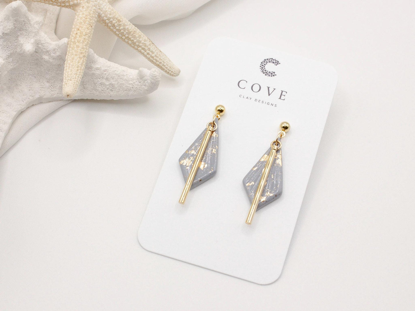 Handmade dusty blue and speckled gold diamond shaped polymer clay earrings with gold bar