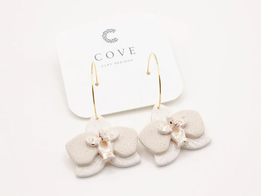 Handmade white orchid flower clay hoop earrings by Cove Clay Designs