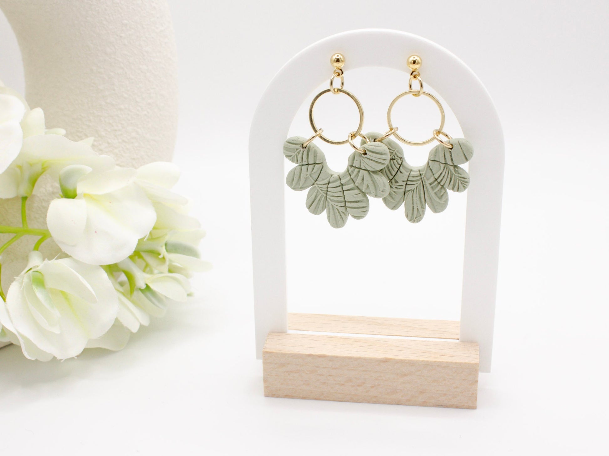 Handmade tropical green leaf polymer clay dangle earrings with gold hoop connectors by Cove Clay Designs