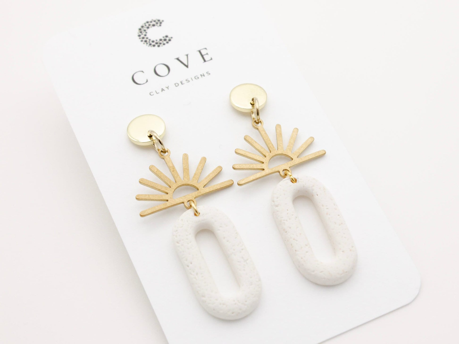 Handmade gold sun and white dangle polymer clay earrings by Cove Clay Designs