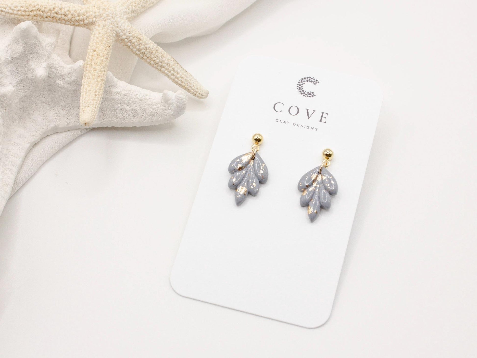 Handmade mini dusty blue and speckled gold leaf polymer clay earrings by Cove Clay Designs