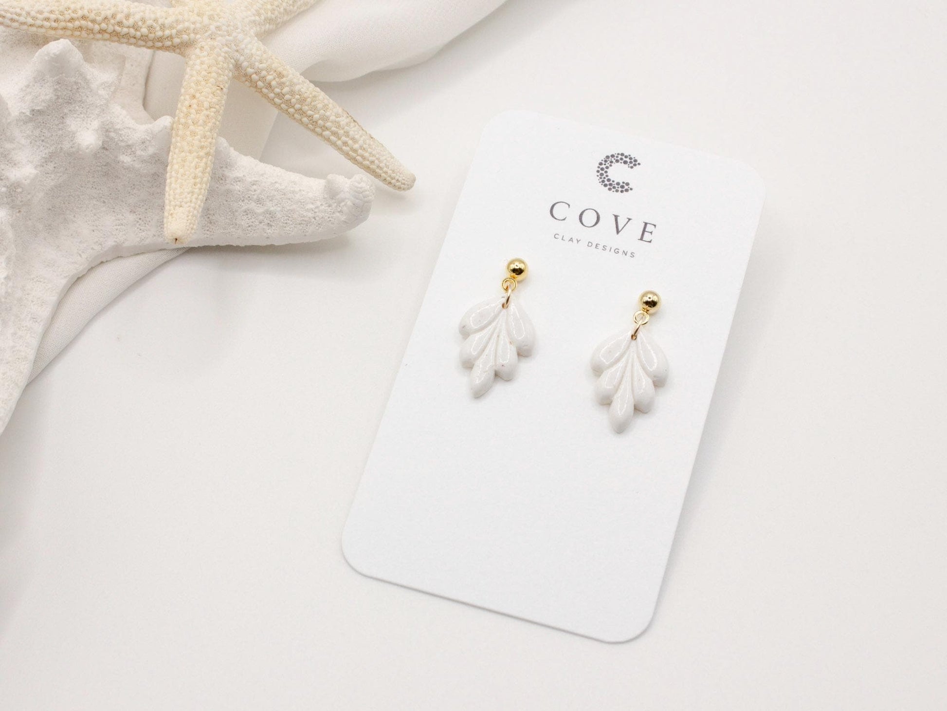 Handmade mini white leaf polymer clay earrings by Cove Clay Designs