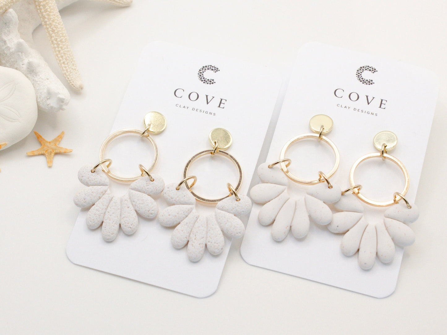 Handmade white sand effect scallop shell hoop dangle clay earrings with gold posts and round connectors by Cove Clay Designs