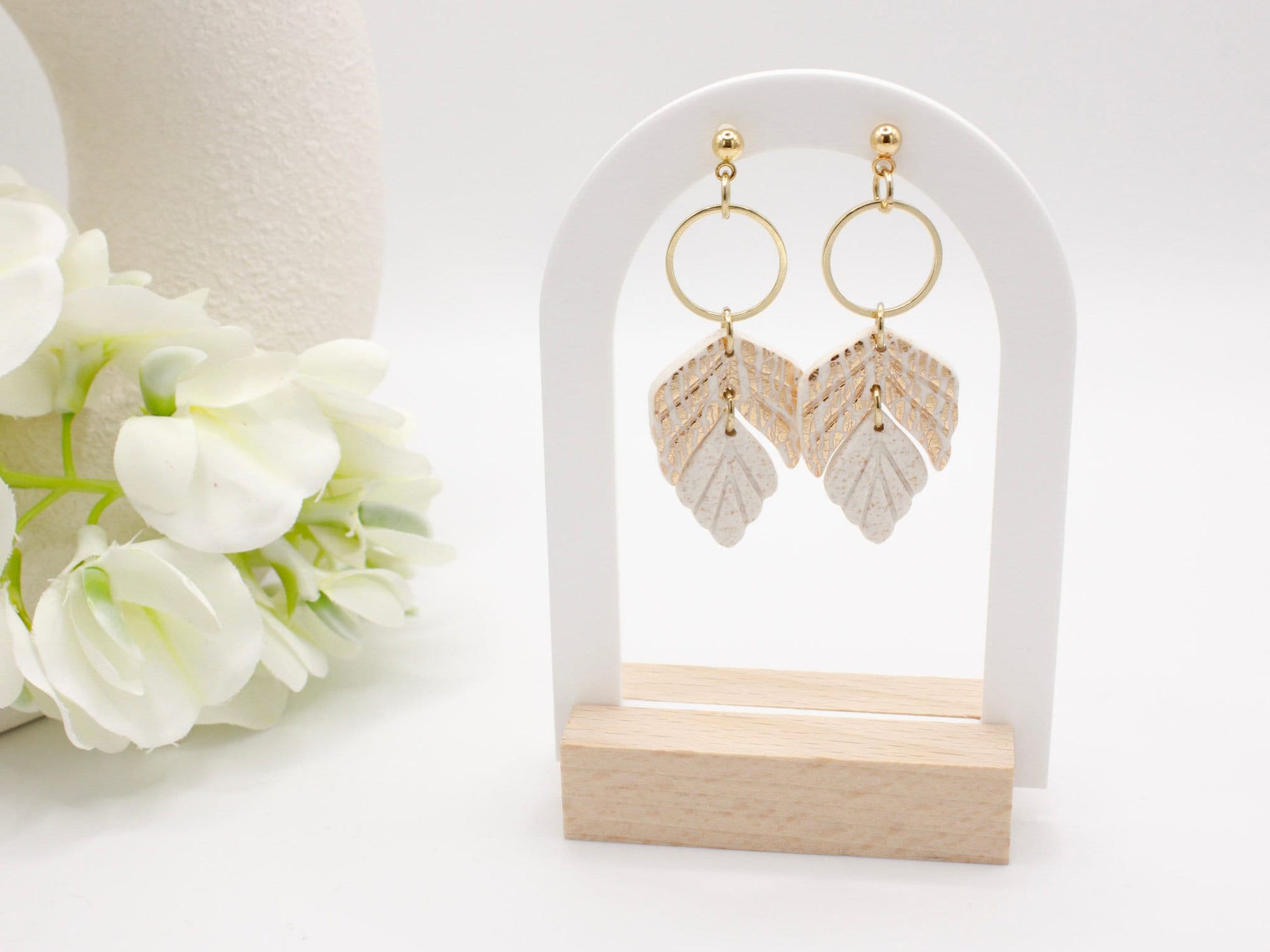 Handmade white and gold leaf clay earrings with gold hoop connectors.