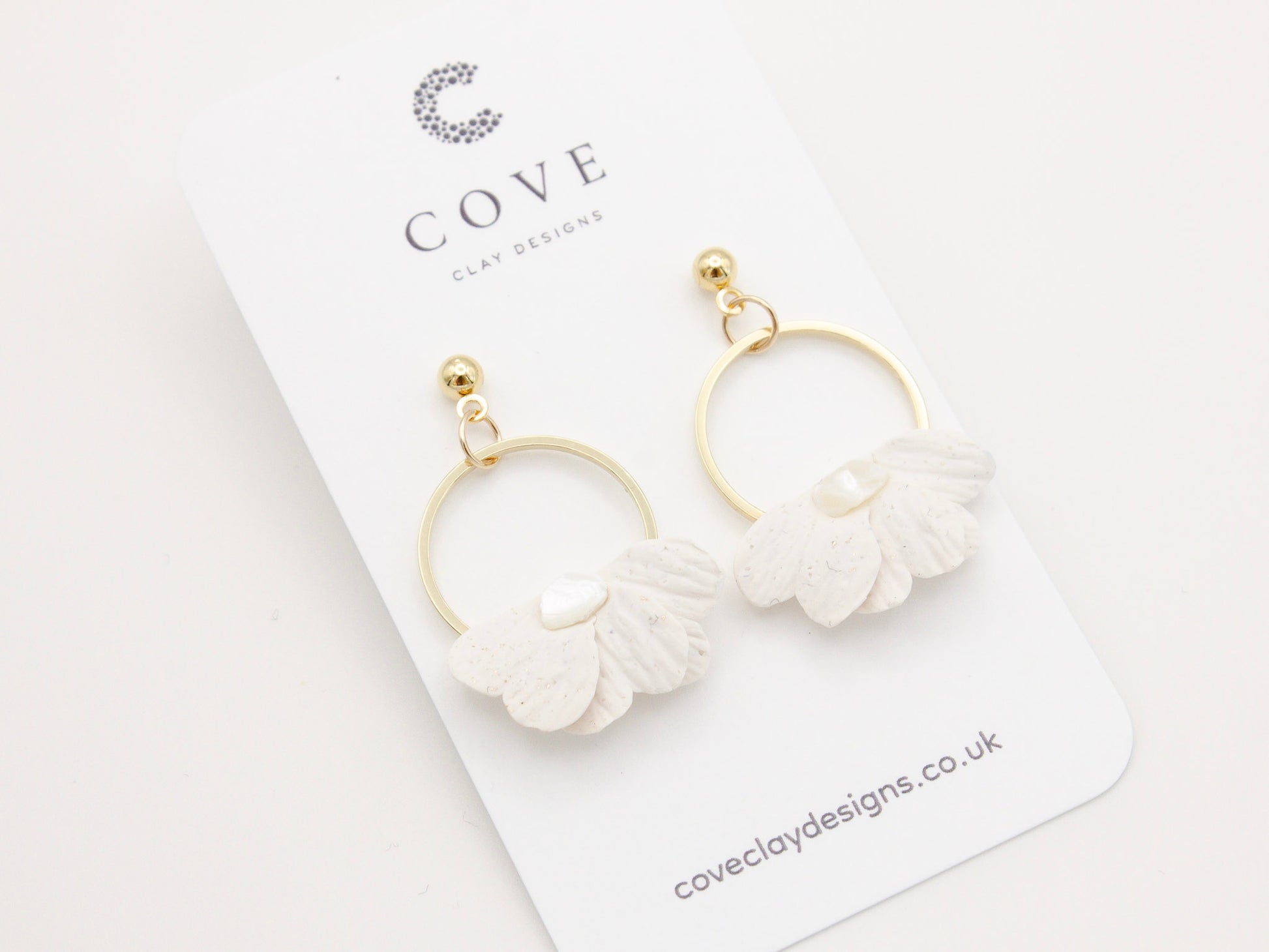 Handmade white petal hoop polymer clay earrings with gold stud posts.