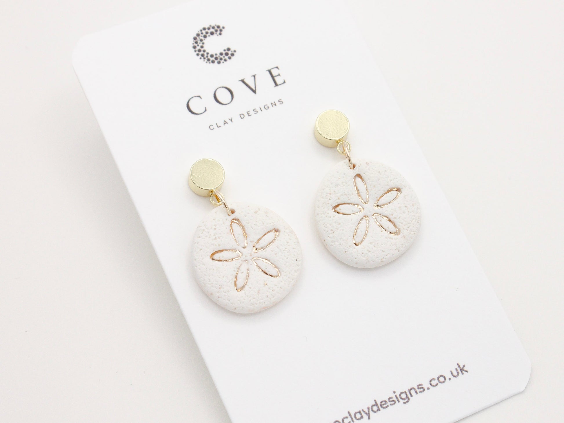 Handmade sand dollar polymer clay earrings with a delicate sand effect finish 