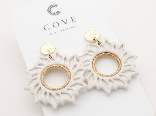 Handmade white sun dangle clay earrings with gold posts by Cove Clay Designs