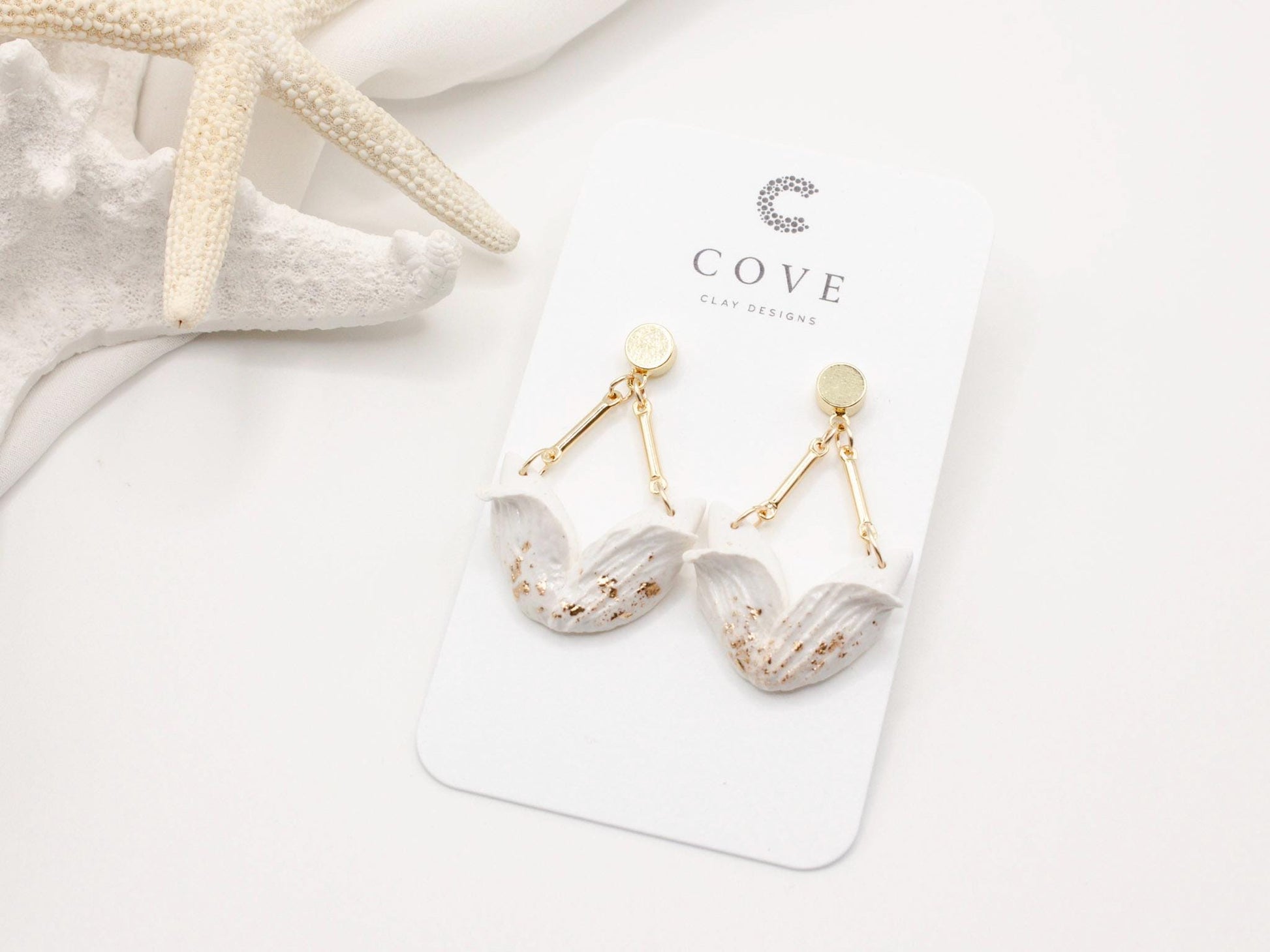 Handmade white tulip inspired clay dangle earrings with gold stud posts by Cove Clay Designs